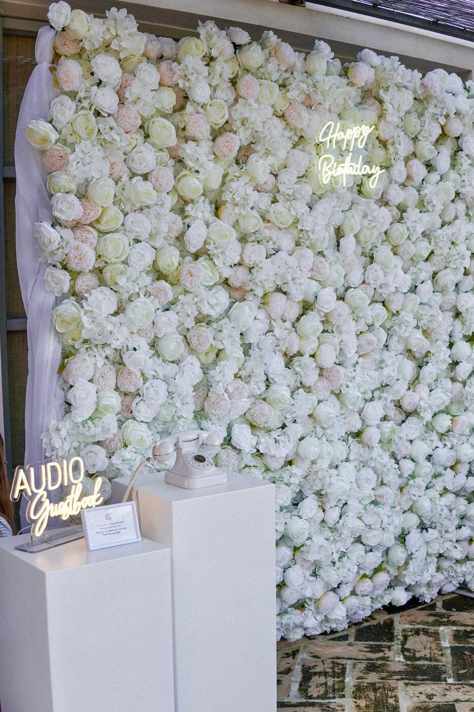 White flower wall with Happy Birthday neon sign and audio guest book telephone, Marbella