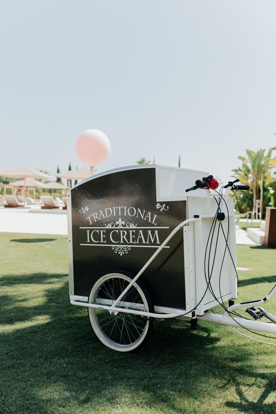 Traditional ice-cream bike with balloon and parasol at a Marbella event