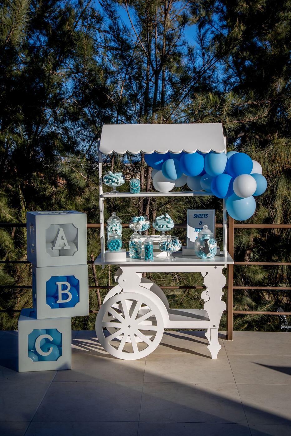 White candy cart styled in blue with ABC letter blocks, Marbella baby shower