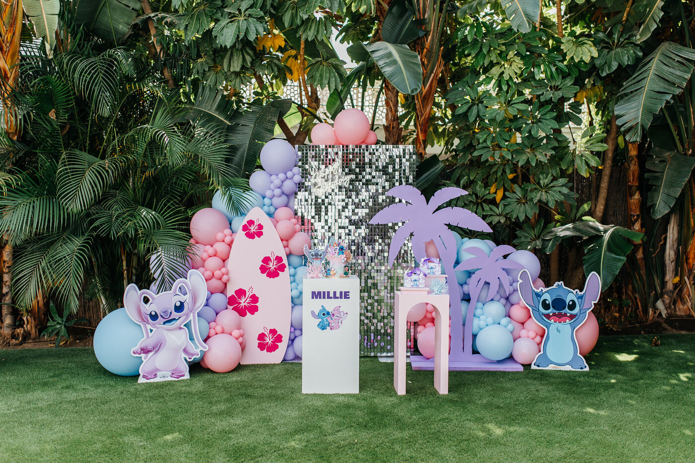 Pastel Stitch themed birthday backdrop with surfboard, palm trees and balloon garlands, Marbella